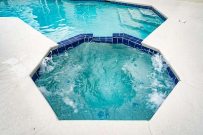 Attached spa with bubbling jets, offering a relaxing spot to unwind right off the private pool.