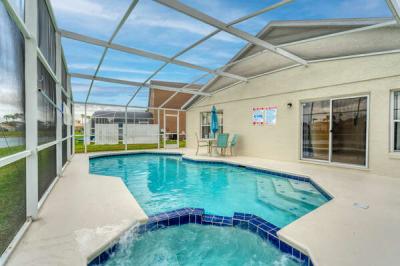 Private screened pool and spa with patio seating, perfect for relaxing and enjoying outdoor Florida living.