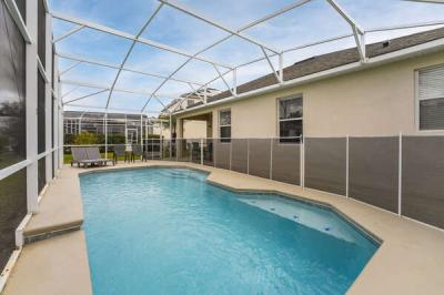 Private screened in pool with child safety fence at a family friendly Central Florida vacation rental near Disney.