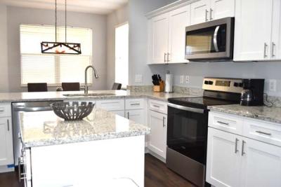Kitchen with island, granite countertops, and stainless appliances.