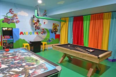 Mario themed game room showing air hockey, pool table, arcades