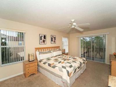 Master bedroom showing king bed and balcony access.
