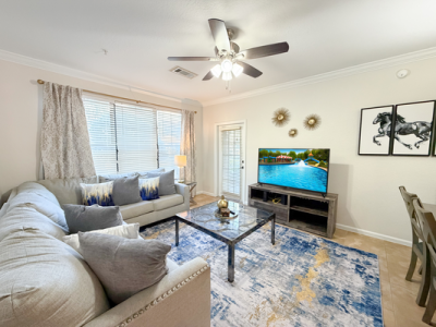Bright Orlando vacation rental living room with sectional sofa, flat-screen tv, and modern dÃ©cor.