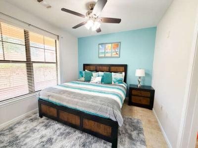 Bright Orlando vacation rental bedroom with king bed, coastal dÃ©cor, and ceiling fan.