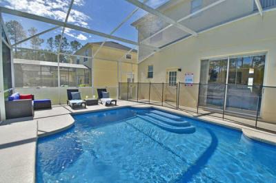 Screened in private pool with sun loungers and safety fence.