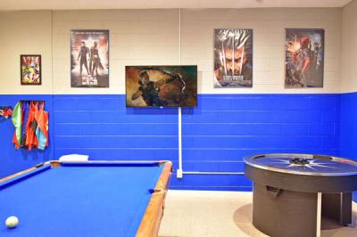 Themed game room with pool table. air hockey table, and wall mounted TV.
