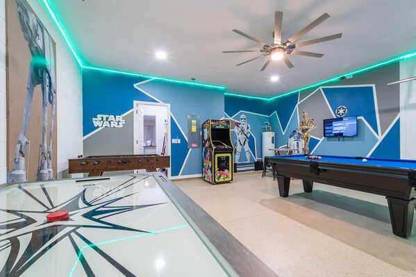 Star Wars themed game room with pool table, air hockey, foosball, arcade machine, and LED accent lighting.