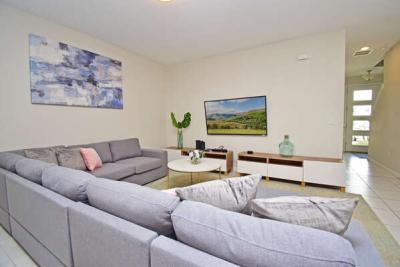 Living room with corner sectional sofa and wall mounted flat screen TV