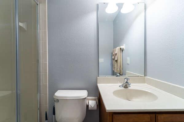 Upstairs en-suite bathroom with walk in shower, vanity sink, and toilet.
