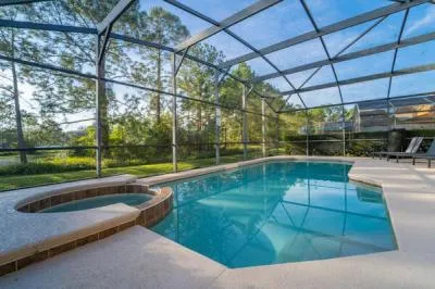 Private screened swimming pool with attached spa and peaceful wooded views, perfect for relaxing after a day of exploring Orlando.