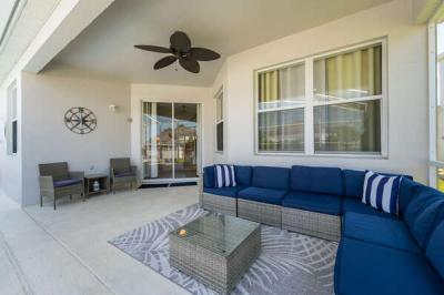 Covered lanai with outdoor seating and ceiling fan.