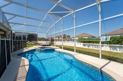 Private screened pool with raised spa and pool safety fence.