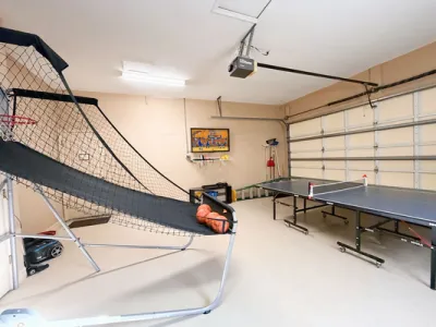 Game room showing ping pong table, basketball game, and TV with Wii games console.