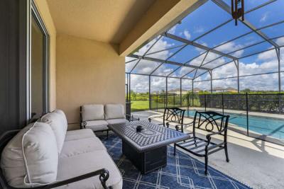 covered lanai with causal seating overlooking the pool