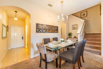 Dining room showing table seating for 6, entry way and the stair location for the second floor.