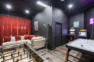 Cozy game room with an air hockey table and arcade machines, perfect for fun and relaxation!
